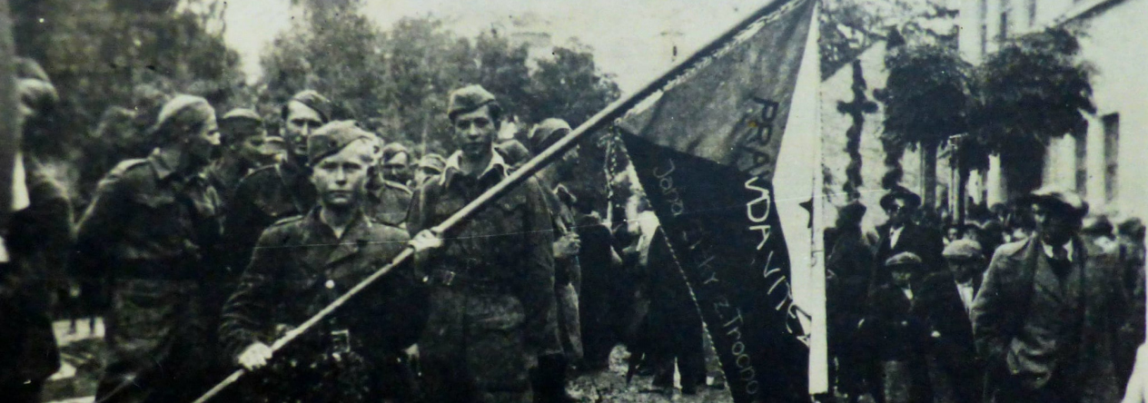 Příslušníci 1. čs. brigády NOVJ „Jana Žižky z Trocnova“ v osvobozeném Daruvaru s novým praporem, 1. října 1944.