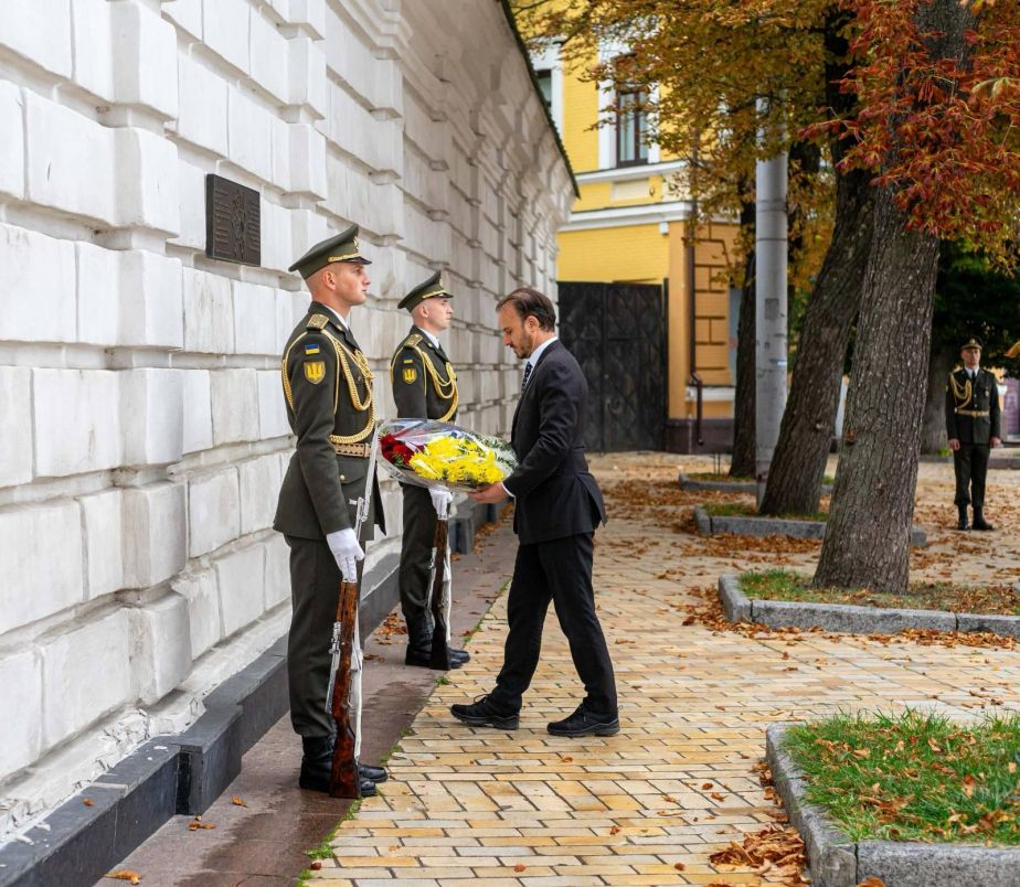 Velvyslanec Luboš Veselý pokládá kytici u pamětní desky.