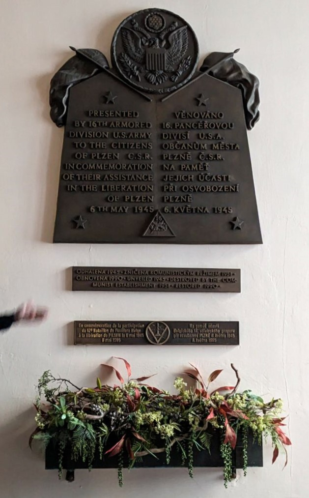 Pamětní deska se znakem a odznakem 16. obrněné (pancéřové) divize armády USA se nachází v budově plzeňské radnice. 