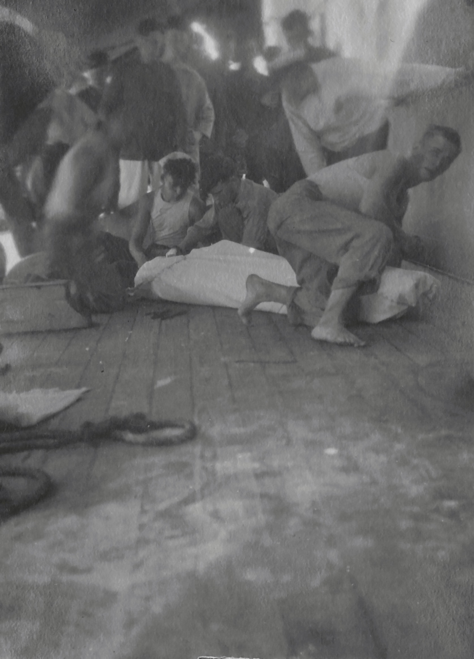Zašívání zemřelého do pytle na palubě lodi President Grant během 23. transportu.
