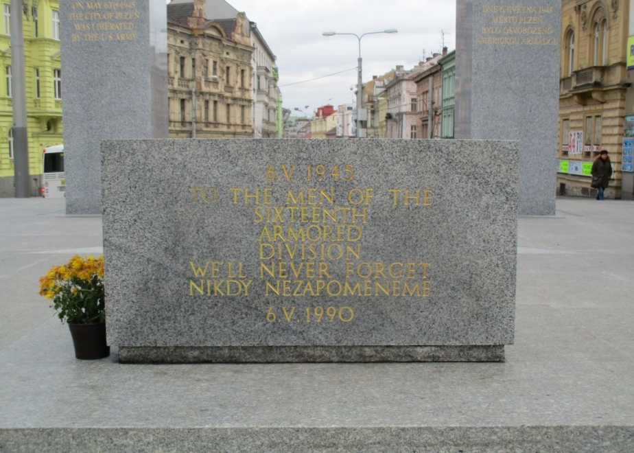 Detail nápisu. Pomník tvoří zpevněná plocha z kamenných žulových desek doplněná uprostřed bílou pěticípou hvězdou s reliéfem. Hlavní dominantu památníku vytvářejí již zmíněné dva žulové pylony, na které navazuje vyrovnávací kamenné schodiště.  