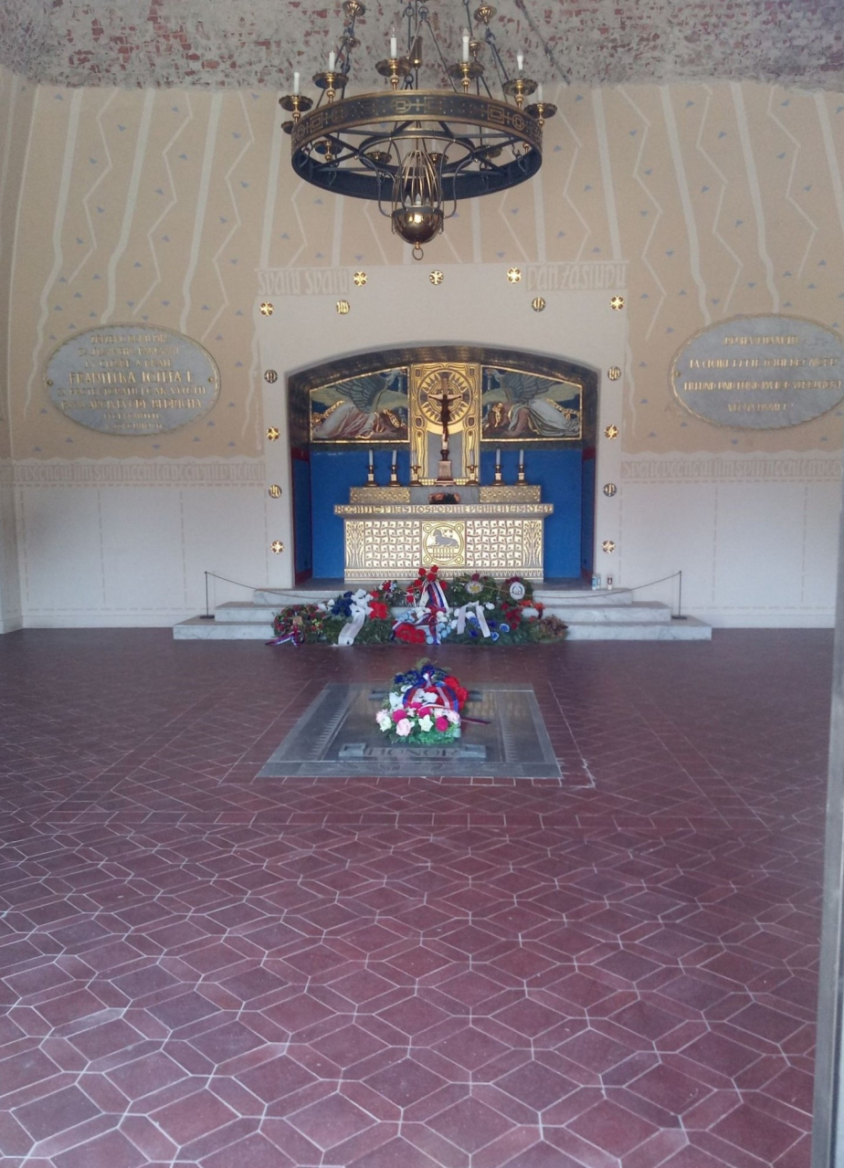 Pohled do kaple nacházející se uvnitř Mohyly míru. Vzadu je vidět oltář a před ním na zemi ossarium. 