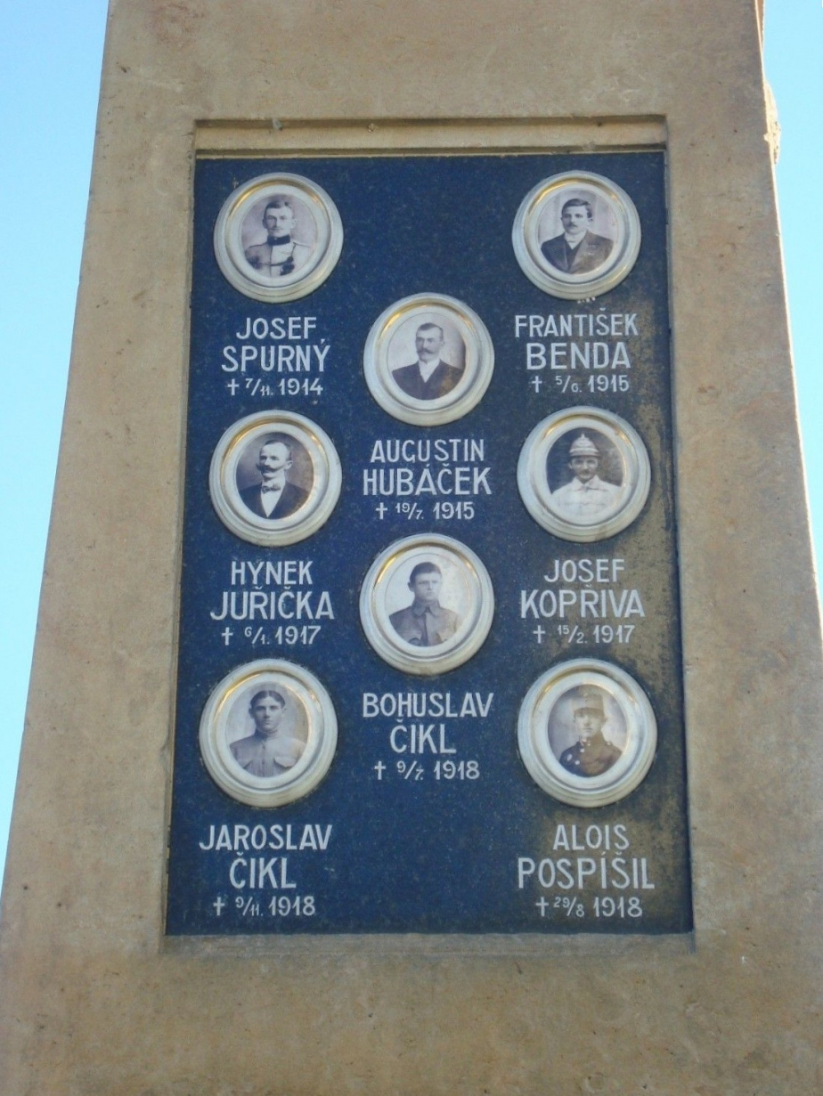 Detailní pohled na podobenky osmi padlých občanů na pomníku v Haňovicích