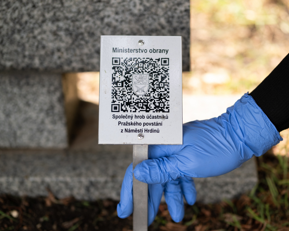 Umisťování informační destičky s QR kódem ke Společnému hrobu účastníků Pražského povstání z Náměstí Hrdinů na Olšanských hřbitovech v Praze.