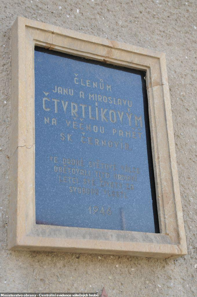 Pamětní deska z černé leštěné žuly s kamenným rámem umístěná na zdi domu v Olomouci – Černovíru je věnována letcům Janu a Miroslavu Čtvrtlíkovým. 