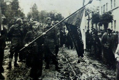 Příslušníci 1. čs. brigády NOVJ „Jana Žižky z Trocnova“ v osvobozeném Daruvaru s novým praporem, 1. října 1944.